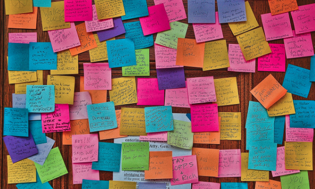 image of dozens and dozens of sticky notes across a door. They are covered in writing in various handwriting.